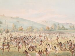 Native americans playing a game on a grassy field.