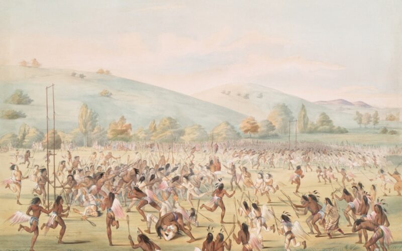 Native americans playing a game on a grassy field.