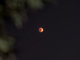 a red moon is seen in the night sky