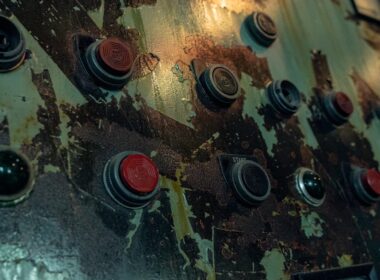 a close up of a metal surface with red and black knobs