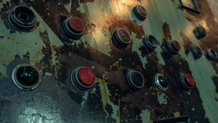 a close up of a metal surface with red and black knobs