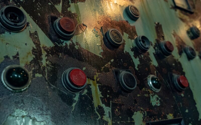 a close up of a metal surface with red and black knobs