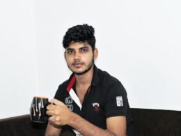 a man sitting on a couch holding a cup