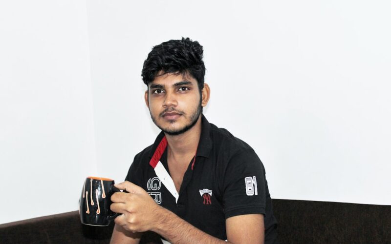 a man sitting on a couch holding a cup