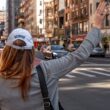 woman in gray long sleeve shirt and blue baseball cap standing on road during daytime