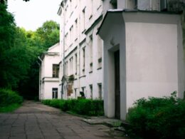 a white building with trees and bushes