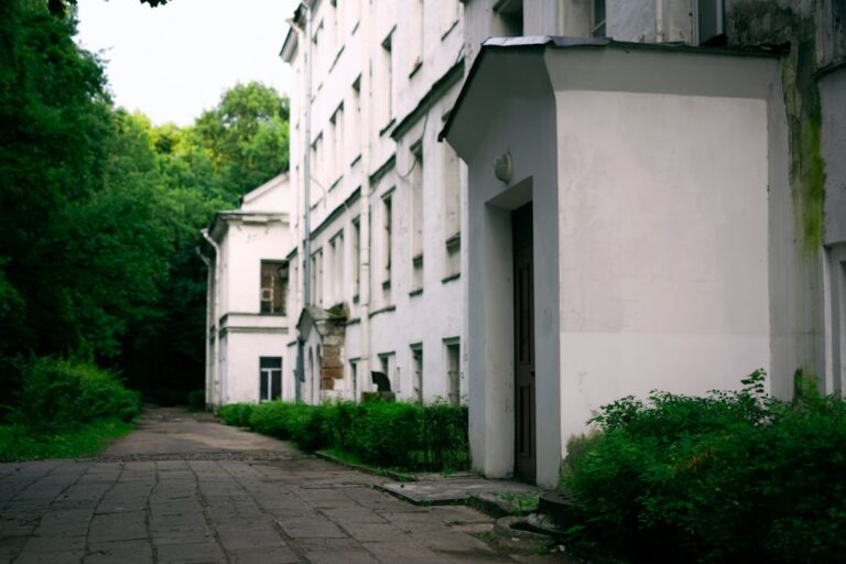 a white building with trees and bushes