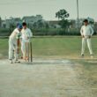 a group of men playing a game of cricket