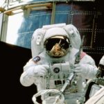 a man in a space suit standing in front of a space station