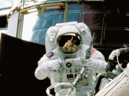 a man in a space suit standing in front of a space station