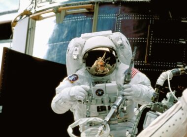 a man in a space suit standing in front of a space station