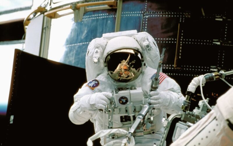 a man in a space suit standing in front of a space station