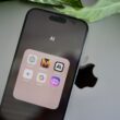 an iphone sitting on top of a table next to a leaf