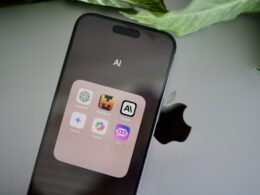 an iphone sitting on top of a table next to a leaf