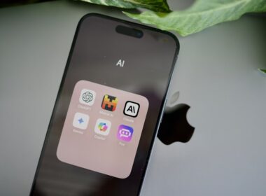 an iphone sitting on top of a table next to a leaf