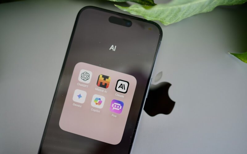 an iphone sitting on top of a table next to a leaf