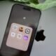 an iphone sitting on top of a table next to a leaf