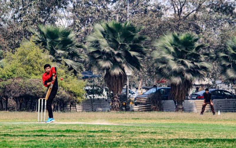 a man playing a game of cricket in a park