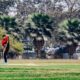 a man playing a game of cricket in a park