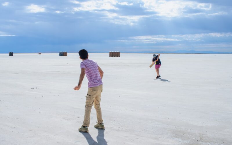 A couple of people that are standing in the sand