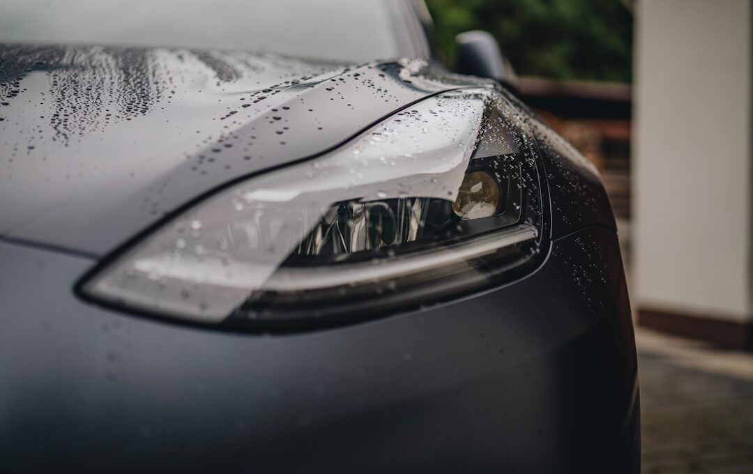 a close up of a car's headlight on a rainy day