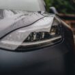 a close up of a car's headlight on a rainy day