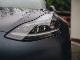 a close up of a car's headlight on a rainy day
