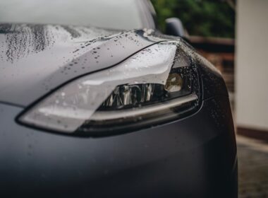 a close up of a car's headlight on a rainy day