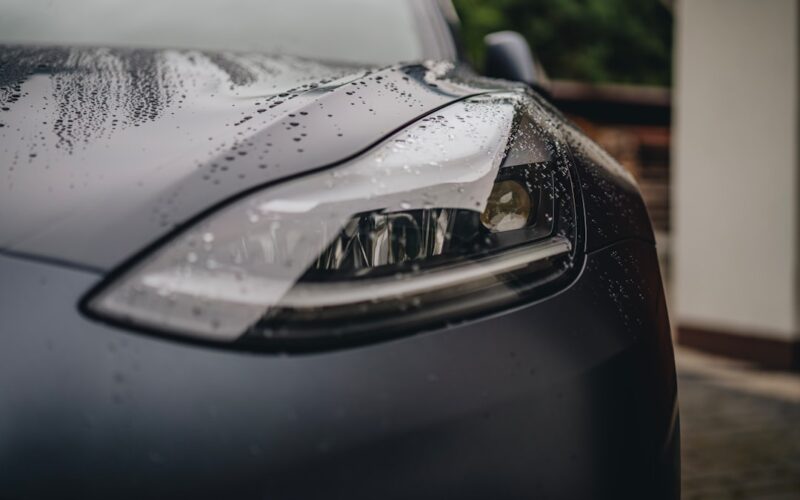 a close up of a car's headlight on a rainy day