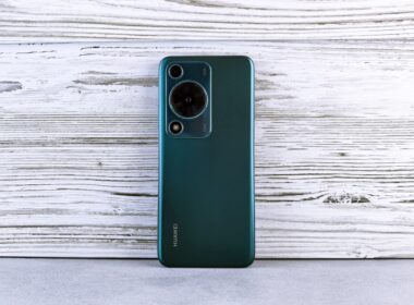 Back of a dark green smartphone with camera