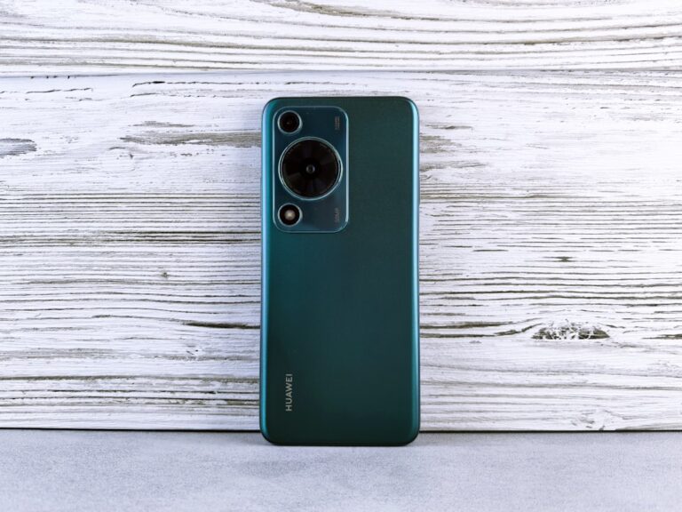 Back of a dark green smartphone with camera