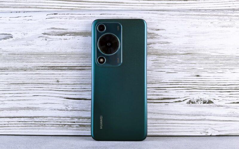 Back of a dark green smartphone with camera