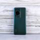 Back of a dark green smartphone with camera