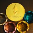 three different colored diamonds next to a gold coin