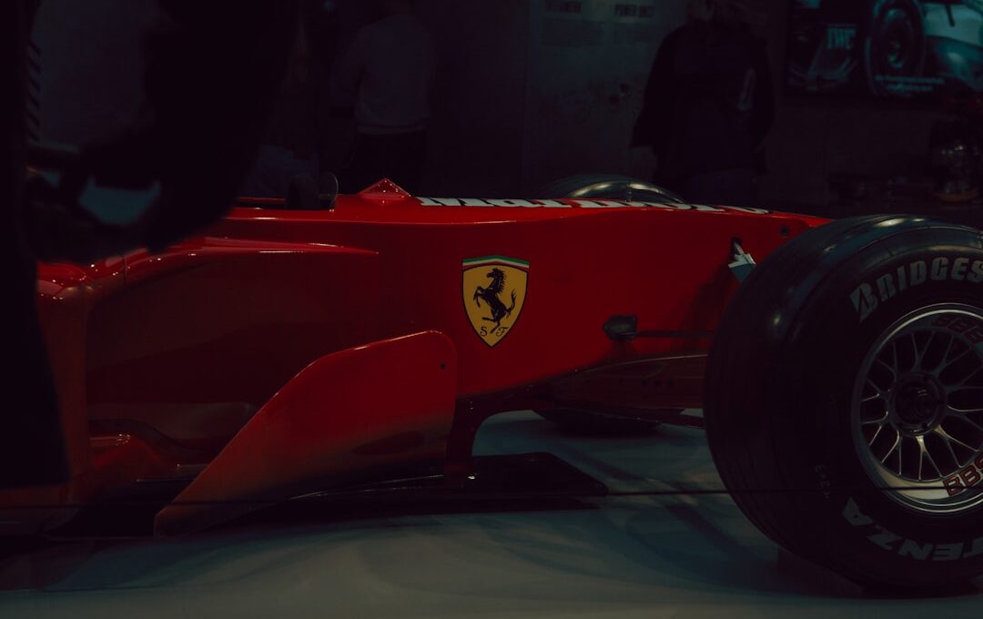 Red ferrari formula 1 car with yellow emblem