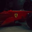 Red ferrari formula 1 car with yellow emblem