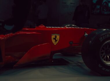 Red ferrari formula 1 car with yellow emblem