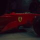 Red ferrari formula 1 car with yellow emblem