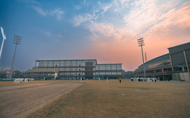 Cricket stadium with floodlights at sunset