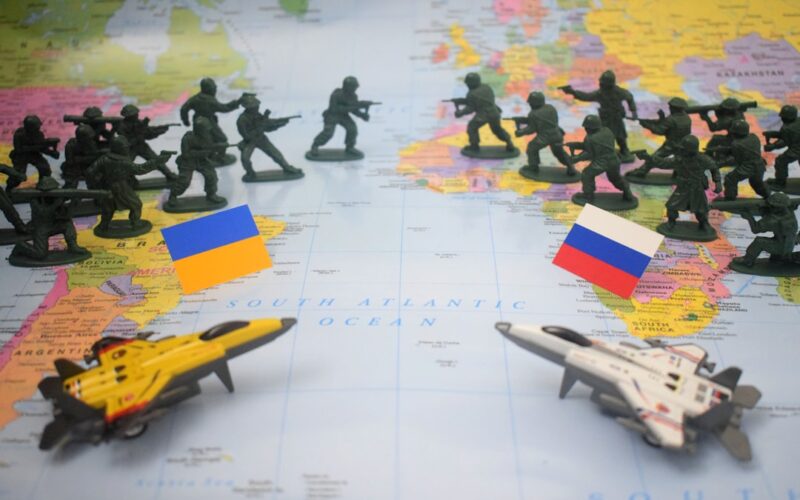 Toy soldiers and jets on map with flags.
