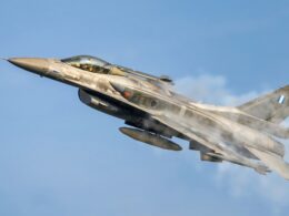 a fighter jet flying through a blue sky