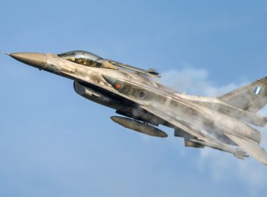 a fighter jet flying through a blue sky