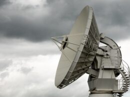 a large satellite dish sitting on top of a metal pole
