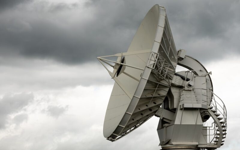 a large satellite dish sitting on top of a metal pole