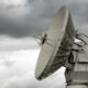 a large satellite dish sitting on top of a metal pole