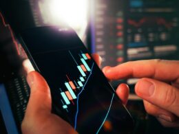 Hands holding smartphone showing stock market data