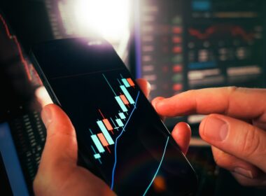 Hands holding smartphone showing stock market data