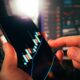 Hands holding smartphone showing stock market data