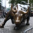 a statue of a bull on a brick street