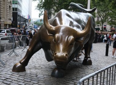 a statue of a bull on a brick street